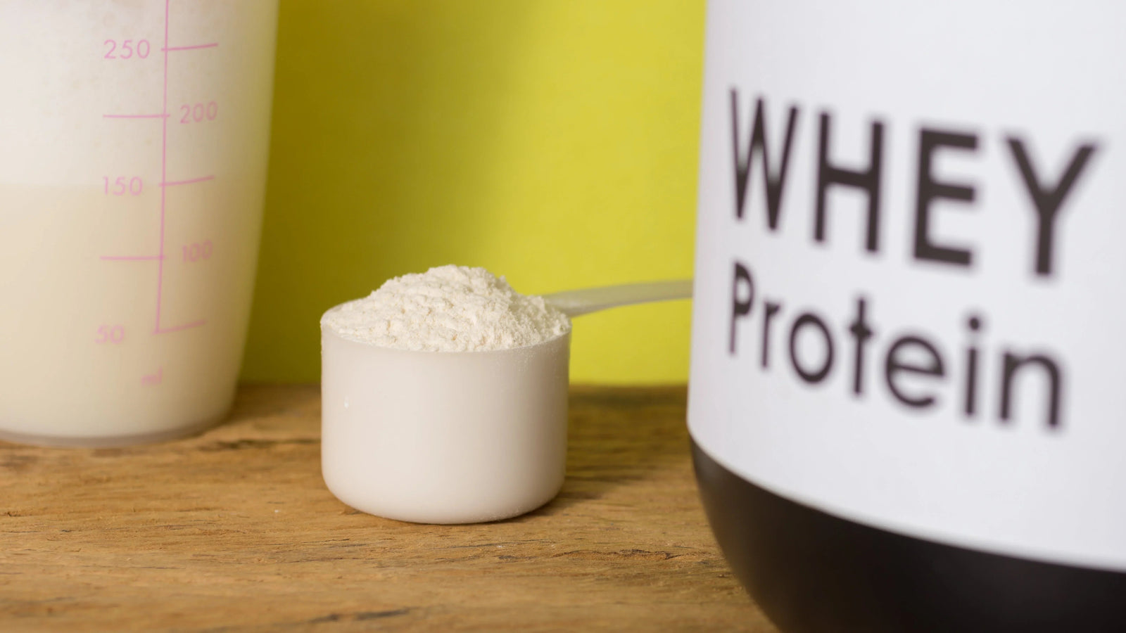 Buy whey protein powder online at Nutristar, close-up of scoop on wooden table
